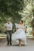 un Boda pareja, un contento novia y novio son corriendo en el parque a el sitio de el Boda ceremonia. Boda concepto foto