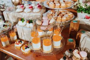 Festive dessert table with sweets. Wedding candy bar, various cakes, chocolates on stands. photo