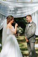 Beautiful wedding couple at a summer wedding ceremony. Wedding vows, emotions and tears photo