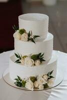 decorated wedding cake, in three tiers, decorated with flowers photo