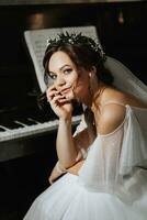 Portrait of a beautiful girl in a wedding dress and a wreath of fresh flowers on her head, playing the piano, playing alone photo