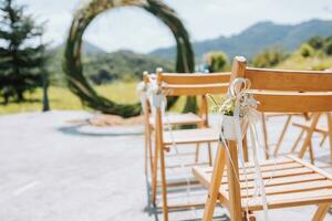 el Boda arco en el parque es hecho de seco cañas en el antecedentes de el bosque en borroso enfocar. lejos Boda ceremonia. decorado sillas para el ceremonia foto