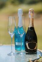 champagne bottles and glasses next to each other on the table. Blue and black champagne photo