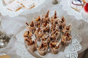 Festive dessert table with sweets. Wedding candy bar, various cakes, chocolates on stands. photo