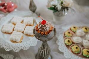 Festive dessert table with sweets. Wedding candy bar, various cakes, chocolates on stands. photo