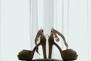 side view, open women's high-heeled shoes in backlight. Women's engagement ring, wedding concept photo