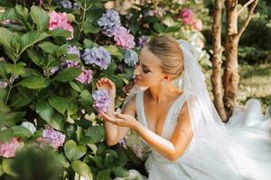 joven hermosa novia en fuera del hombro Boda vestir cerca hortensia flores, Moda foto tomado debajo suave luz de sol