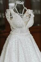 un Exquisito Boda vestir bordado con blanco perlas con un muy bajo escote en un maniquí en el de la novia habitación. foto
