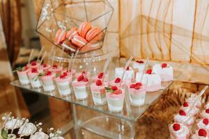 Festive dessert table with sweets. Wedding candy bar, various cakes, chocolates on stands. photo