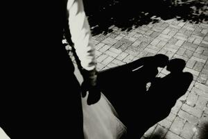 el novia y novio caminar después el Boda ceremonia. negro y blanco foto, sombra en el loseta desde el novia y novio foto