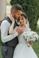 un hermosa boda, un hermosa Pareja en amar, riendo y besos en contra el antecedentes de un verde jardín. alto calidad foto
