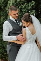 un hermosa boda, un hermosa Pareja en amar, riendo y besos en contra el antecedentes de un verde jardín. alto calidad foto