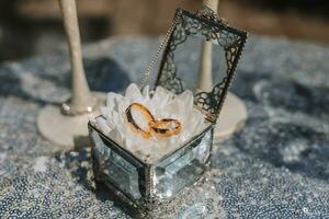 Boda anillos en un vaso caja, en un blanco flor. Boda detalles. fiesta concepto. el lentes son decorado con cristal flores foto