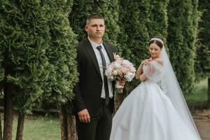 el novia y novio actitud en contra el antecedentes de verde arboles Boda caminar en naturaleza en el parque foto