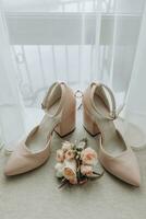 Beige open elegant shoes. A wedding ring with a diamond, a wedding ring made of roses. Fashion. Style. Wedding photo