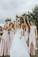 grupo retrato de el novia y damas de honor teniendo divertida. boda. un novia en un Boda vestir y su amigos en rosado vestidos en el Boda día. elegante Boda en polvo color. concepto de casamiento. foto