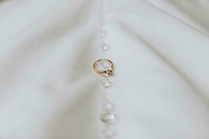 Golden women's ring with a precious stone on a white background photo