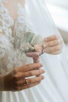 bride is holding boutonniere in her hands. wedding flowers. photo