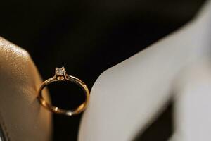 gold women's ring on a dark background, a man makes a marriage proposal to his girlfriend photo