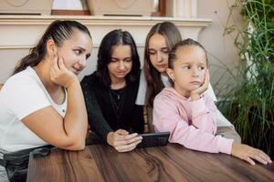 A child gets bored while adults or teenagers are busy or the concept of the effect of mobile phones on children's development, photo with selective soft focus