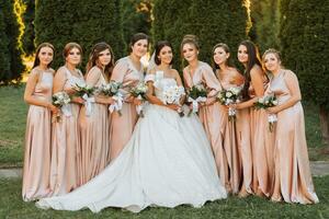 Beautiful elegant slim smiling bridesmaids in delicate pink beige summer dress on the wedding ceremony. photo