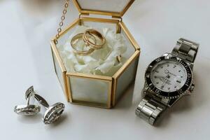 expensive men's watch. Cufflinks. Glass box with wedding rings. Details of the groom photo