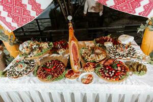 Snacks at the wedding, cheese, sausage, vegetables, meat products, Cossack table at the Ukrainian wedding. photo