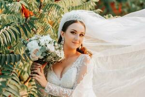 retrato de el novia con un ramo. un hermosa joven novia sostiene un Boda ramo de flores en su manos. Boda pelo y maquillaje foto