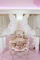 un delicioso boda. blanco pastel decorado con flores caramelo bar para un banquete. celebracion concepto. de moda postres mesa con dulces, dulces. frutas foto