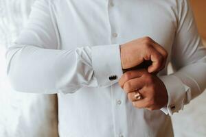 Close-up of a man and a button-down shirt. clothing for interviews, work and corporate fashion for business. The hands of a male person, the groom is preparing for the wedding photo