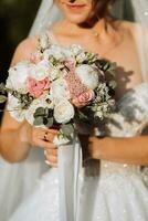 a bouquet of flowers close-up in the hands of the bride and groom photo