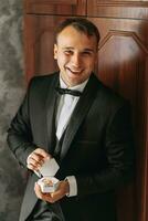 Preparation for the morning of the bride and groom. portrait photo of an elegant man getting dressed for a wedding celebration. The groom, dressed in a white shirt and bow tie