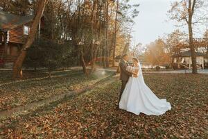 Portrait of the bride and groom in nature, a beautiful couple in love. Autumn tree leaves. The newlyweds are walking in the autumn park photo