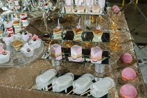 un dulce mesa a un boda. mesa con pasteles y dulces a el festival. cumpleaños dulces foto