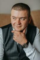 Portrait of a man with a stylish watch in a business suit. the groom is preparing for the ceremony. Friends help the groom prepare for the wedding. The man puts on a suit and prepares for the meeting photo