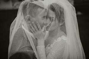 Boda Pareja en naturaleza. novia y novio abrazando debajo el velo a boda. foto