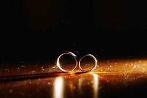 dos Boda anillos en infinito firmar con espumoso ligero neblina. amor concepto en negro antecedentes foto