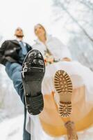 novio y novia en cuero botas a un invierno boda. de cerca de novia y novio zapatos. Boda en invierno. foto