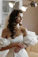 Portrait of a beautiful bride in a luxurious wedding dress. Elegant bride with long curly hair in a delicate white wedding dress photo