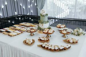 Wedding monobloc with delicious desserts. Strawberry cupcakes, jellies and modern desserts, stylish restaurant wedding decorations photo