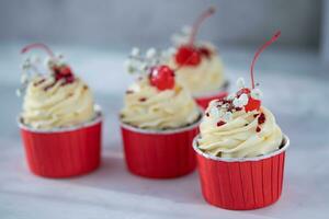 Cupcakes with cherry on a red napkin on a white background photo