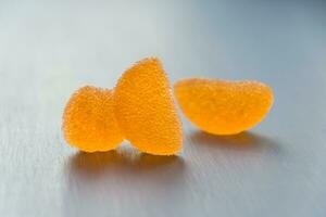 Orange jelly candies on a gray background. Selective focus. photo