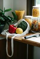 Vegetables in a mesh bag on the kitchen countertop. photo