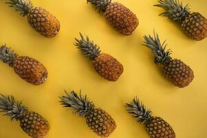 Pineapple pattern on yellow background. Minimal summer concept. photo