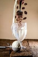ice cream in a glass on a wooden table with a spoon and chocolate chips photo