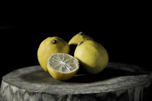 lemons on a wooden table on a black background in the studio photo