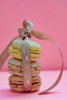 Macaroons with ribbon on pink background. Selective focus. photo