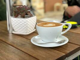 Coffee cup on wooden table in coffee shop, stock photo