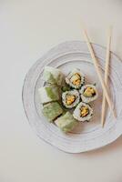 Sushi roll with salmon, avocado, cucumber and cream cheese inside photo