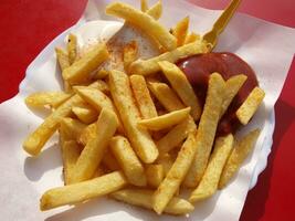 francés papas fritas con salsa de tomate y mayonesa en un blanco plato foto